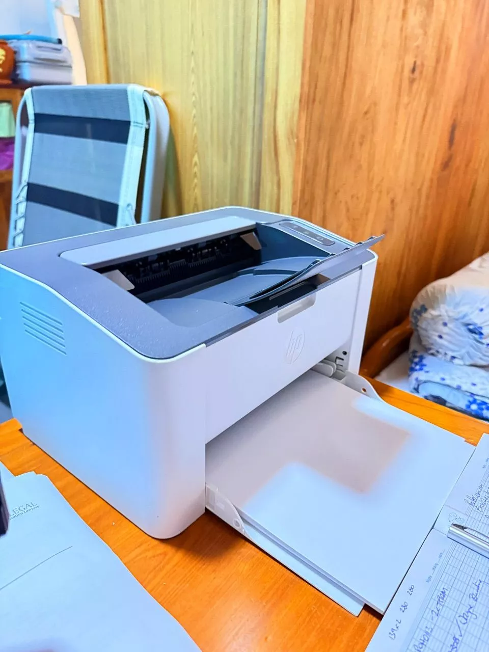 Ảnh khách chụp máy HP Laser 108w trên bàn gỗ, khay giấy đang mở
